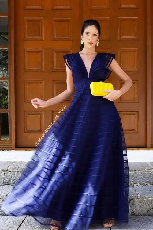 Look com vestido azul marinho e clutch amarela