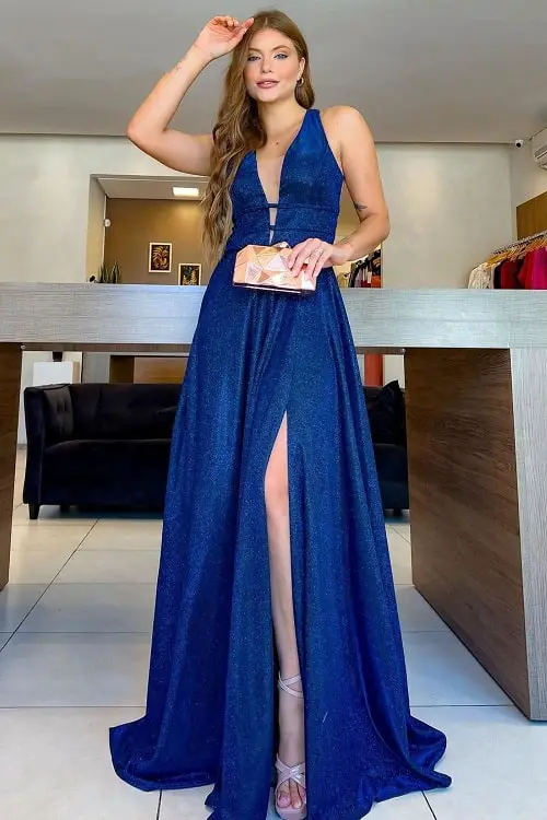 Look com vestido azul marinho e clutch dourada