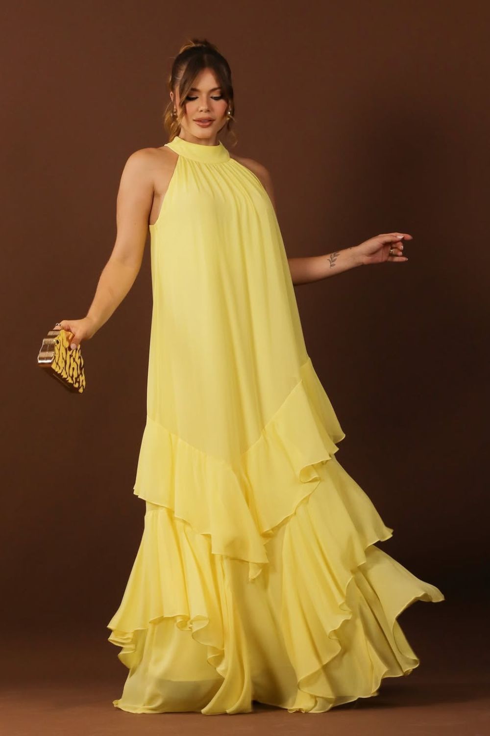 Look com vestido amarelo e clutch dourada